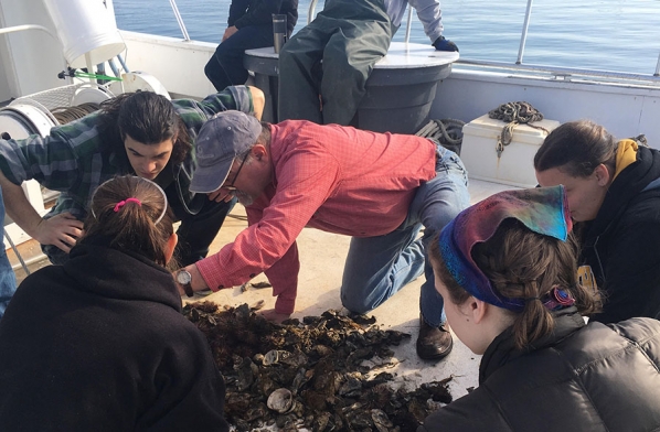 Dr. Steve Hageman, center, shows paleontology students communities of marine organisms on the deck of the University of North Carolina Institute of Marine Science’s research vessel in the spring of 2018. 