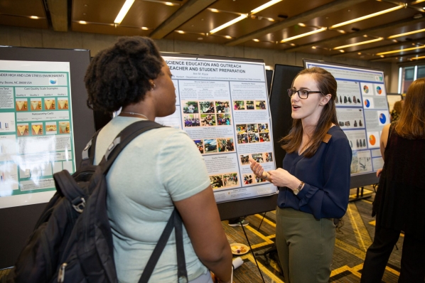 Klyce speaks with fellow GES major Neeshell Bradley-Lewis at OSR poster day