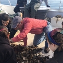 Dr. Steve Hageman, center, shows paleontology students communities of marine organisms on the deck of the University of North Carolina Institute of Marine Science’s research vessel in the spring of 2018. 