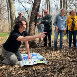 Tucker Terrell ’25, who graduated from App State in May with a bachelor’s degree in geology-environmental geology, far left, shows community members where a single headstone was located by App State researchers trying to determine the position of grave sites in an area formerly covered with brush behind the Fort Defiance site in Caldwell County. Photo by Bret Yager