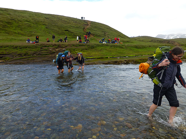 Students wading through Iceland glacial stream